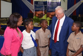 Justice Minister, Hon. Delroy Chuck (second right), speaks with Pembroke Hall Primary School student, Raphael Thorne (centre), at a restorative justice youth awareness forum held on Wednesday (February 5), at the school in Kingston. Looking on are (from left) Programme Coordinator, Restorative Justice Unit, Andrine Lindsey; and Rickala Parish and Malik Scott from the John Mills Infant, Primary and Junior High School.