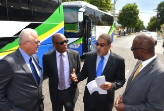 Minister of Justice, Hon. Delroy Chuck (left), in conversation with (from second left): Member of Parliament for North East St. Catherine, Leslie Campbell; Opposition Spokesperson on Tourism, Wykeham McNeill and Executive Director of the Legal Aid Council, Hugh Faulkner, at a special viewing of new mobile justice units (in background) by Cabinet Ministers and Members of Parliament, on Duke Street in downtown Kingston, on February 4.