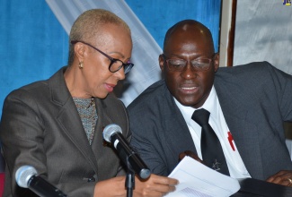 Minister of Science, Energy and Technology, Hon. Fayval Williams (left), discusses an important aspect of a document with Principal Director for Energy in the Ministry, Fitzroy Vidal. Occasion was a press conference held at the Trafalgar Road offices of the Petroleum Corporation of Jamaica (PCJ), on Monday (February 24).
