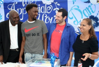 Kidney donor, Kirk ‘Dan’ Cross (left), and kidney recipient, nephew, Kasey Tulloch (second left), share a happy moment, at Mr. Cross’ residence in Kitson Town, St. Catherine, at a ‘Thank You’ lunch, on  February 29. With them (from left) are Assistant Professor of Surgery at New York University (NYU), Dr. Bruce E. Gelb, and Administrative Nurse at NYU, Margaret Frank Bader.