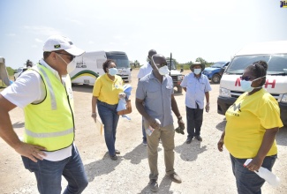 Health and Wellness Minister, Dr. the Hon. Christopher Tufton (left), is in Corn Piece, Clarendon on Monday (April 13), to observe the first deployment of a coronavirus (COVID-19) mobile testing unit to the area. He is joined by Member of Parliament for South East Clarendon, Hon. Pearnel Charles Jr (centre), and personnel from the Ministry.