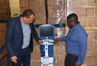 Minister of Health and Wellness, Dr. the Hon. Christopher Tufton (left), and National Health Fund (NHF) Chief Executive Officer, Everton Anderson, examine one of several ventilators that were among an initial shipment of medical equipment and supplies procured by the Government in response to Jamaica’s coronavirus (COVID-19) outbreak. The Minister visited the NHF warehouse in Kingston, where the items are being stored, on Wednesday (April 8).