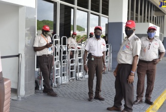 Red Cap porters based at the Sangster International Airport in Montego Bay, St. James, await the arrival of travellers outside the departure lounge as the airport reopened for international travel on Monday (June 15).