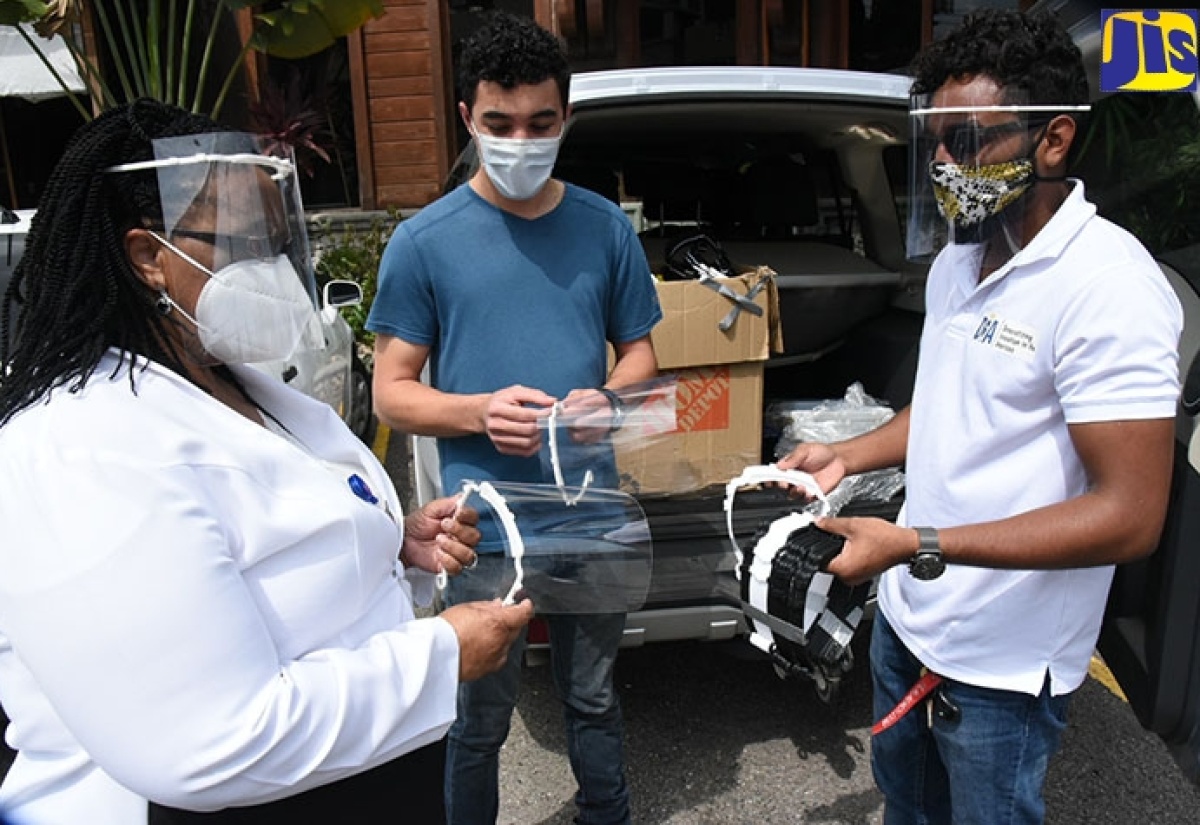 Regional Director, South East Regional Health Authority (SERHA), Dr. Sandra Chambers (left), examines one of the face shields donated by Citizens Response Jamaica. The entity handed over 1,000 face shields to SERHA at a ceremony held on June 16 at Blue Dot Insights, in Kingston. Sharing the moment are members of Citizens Response Jamaica, Kriston Kong (centre) and Shane Smith. Citizens Response Jamaica was born out of a shared goal of contributing to the fight against the COVID-19 pandemic.