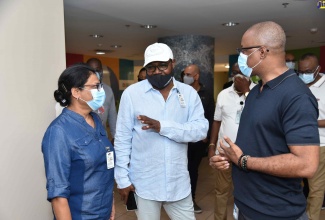 Minister of Tourism, Hon Edmund Bartlett (centre) discusses the preparations that have been made at the Sangster International Airport to facilitate the reopening of the tourism sector on Monday (June 15), with Chief Medical Officer, Dr Jacqueline Bisasor-McKenzie (left) and Permanent Secretary in the Ministry of Health and Wellness, Dunstan Bryan, during an inspection of the airport ahead of Monday’s reopening of the facility to international tourist travel.  Minister Bartlett led a team that observed health protocols to detect and guard against the Coronavirus (COVID-19). 