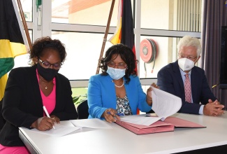 Chief Executive Officer of the Bustamante Hospital for Children, Camile Wallen Panton (left), signs the contract for personal protective equipment (PPE) valued more than US$10,000, from the German Embassy to the hospital, today (June 15), at the  embassy on Waterloo Road in St. Andrew. Observing are Senior Medical Officer (SMO) at the hospital, Dr. Michelle-Ann Richards-Dawson, and Ambassador of the Federal Republic of Germany to Jamaica, Dr. Bernd von Munchow-Pohl.