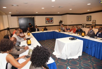 Government officials (at right)  in discussion with Members of the Opposition,  led by Leader of the Opposition, Dr. Peter Phillips (fifth left), about the National Identification System (NIDS). The meeting was held at The Jamaica Pegasus in New Kingston, earlier this year.

