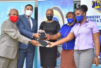 Prime Minister, the Most Hon. Andrew Holness (second left); Chairman, e-Learning Jamaica Company Limited (e-LJam), Christopher Reckord (left) and Minister of Science, Energy and Technology, Hon. Fayval Williams, hand over tablets to Principal, Balcombe Drive Primary School, Yvette Foster (second right); and teacher, Anishka Baker Samuels, at the school on July 9.


