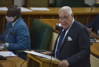 Minister of Labour and Social Security, Hon. Mike Henry, making his contribution to the 2020/21 Sectoral Debate in the House of Representatives on July 21. At left is Minister of Local Government and Community Development, Hon. Desmond McKenzie.