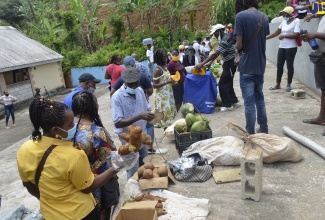 Customers and vendors conduct business at a mini farmers' market in Cascade, Hanover, on July 2. The event was organised  by the Social Development Commission (SDC).