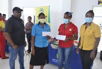 Icema Brown-Sanderson ((second left), operator of Icema’s Hats and Accessories and Madge Corniffe (second right) of Cestan Hills Nature’s Beauty and Delight, show off their grant awards, while Social Development Commission (SDC) Hanover parish manager, Mashario Bisasor (left) and Director of Local Economic Development and Community Projects at the SDC, Avril Ranger, share the moment. The grants were handed over at the Hopewell Sports and Community Centre in Hanover on July 2, during an SDC-organised farmers’ market and bus tour, which stopped in various communities throughout the parish.  A total of seven grants ranging from $15,000 to a maximum of $115,000 were presented to seven entrepreneurs on the day.