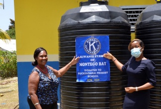 President of the Kiwanis Club of Montego Bay, Teisha-Ann Pinnock (right), hands over a 680-gallon water tank to Principal of the Buckingham Primary and Infant School in Hopeton, St. James, Marcia Findlater-Dixon, at the school grounds on Wednesday (July 29).

 