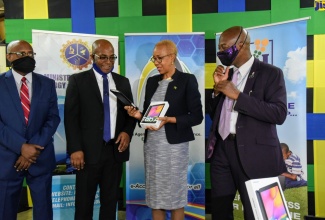 Minister of Science, Energy and Technology, Hon. Fayval Williams (second right), examines one of the tablet computers distributed to educators at the Hope Valley Experimental School, located at 2-4 University Road, Kingston 7, on July 7. With the Minister (from left) are Chief Executive Officer, e-Learning Jamaica Company Limited, Keith Smith; Principal, Hope Valley Experimental School, Anthony Grant; and Chief Executive Officer, Universal Service Fund, Daniel Dawes. The initiative falls under the Government’s Tablets for Teachers Programme.