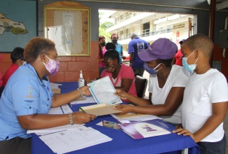 Project Assistant, Integrated Community Development Project at the Jamaica Social Investment Fund (JSIF), Sabrena Mindley (left), distributes birth certificates to residents of Steer Town in St. Ann, recently. The birth certificates were distributed through Operation Certification, an initiative between the JSIF and the Registrar General’s Department.

