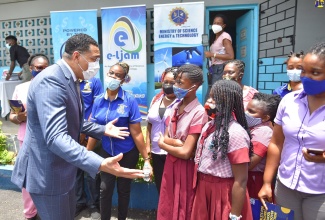 Prime Minister, the Most Hon. Andrew Holness (left), speaks with students and teachers at Balcombe Drive Primary School in Kingston, on Thursday (July 9), after handing over tablets to  teachers at the institution.