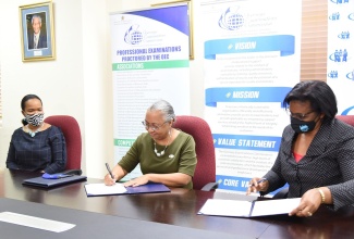 ​Managing Director of HEART/NSTA Trust, Dr.  Janet Dyer (right), along with Deputy Director of the Overseas Examinations Commission (OEC) with responsibility for the administration of examinations, Sharon Burnett (centre), sign a Memorandum of Understanding (MOU) for the OEC to administer the National Council on Technical and Vocational Education and Training (NCTVET) examinations for the period November 2019 to November 2022. Witnessing the signing (at left) is Acting Chief Education Officer in the Ministry of Education, Youth and Information, Dr. Kasan Troupe. The signing took place on July 23, at the OEC offices, 6 Manhattan Road, Kingston.

