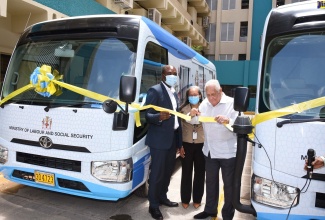 Minister of Labour and Social Security, Hon. Mike Henry (right), cuts the ribbon to commission into service two mobile units at the Ministry’s downtown Kingtson offices on Thursday (July 9). Sharing the moment are Permanent Secretary in the Ministry, Collette Roberts-Risden (centre); and State Minister, Hon. Zavia Mayne.

