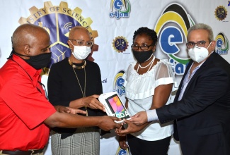 Minister of Science, Energy and Technology, Hon. Fayval Williams (second left), participates in the handover of a tablet to Principal of the August Town Primary School, Jennifer Solomon (second right) during a ceremony held on July 15 at the school in St. Andrew. Others (from left) are Chief Executive Officer of e-Learning Jamaica, Keith Smith; and school Board Chairman, Andrew Warwar.