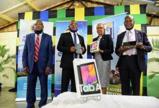 Minister of Science, Energy and Technology, Hon. Fayval Williams (second right), holds one of the tablet computers distributed to teachers at the Hope Valley Experimental School, St. Andrew on July 7. From left are: Chief Executive Officer, e-Learning Jamaica Company Limited, Keith Smith; Principal, Hope Valley Experimental School, Anthony Grant; and Chief Executive Officer, Universal Service Fund, Daniel Dawes. The initiative falls under the Government’s Tablets for Teachers Programme.