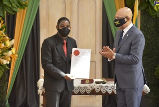 Governor-General, His Excellency the Most Hon. Sir Patrick Allen (right), applauds as newly appointed Judge of the Court of Appeal, Justice David Fraser, displays his Instrument of Appointment during a swearing-in ceremony for  nine Judges on Monday (September 14) at King's House. 

