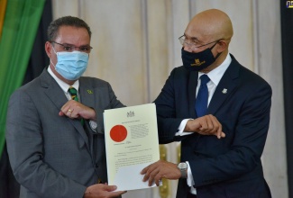 Governor-General, His Excellency the Most Hon. Sir Patrick Allen (right), congratulates Minister of Energy, Science and Technology, Hon. Daryl Vaz (left), after presenting him with the Instrument of Office at the swearing-in ceremony for Cabinet Ministers at King’s House on Sunday (September 13).

 