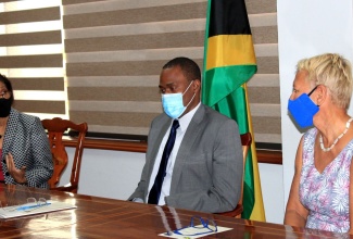 Minister of Finance and the Public Service, Dr. the Hon. Nigel Clarke (centre), and outgoing Head of the European Union Delegation to Jamaica, Belize, The Bahamas, Turks & Caicos Islands, and Cayman Islands, Ambassador Malgorzata Wasilewska (right), in discussion with Permanent Secretary in the Ministry of Justice, Sancia Bennett-Templer, during a courtesy call and brief ceremony at the Finance Ministry’s offices in Kingston, on Friday (September 11), for the formal handover of the EU-funded Jamaica Justice Sector Reform Programme to the Government.

