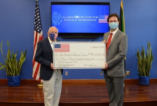 U.S. Ambassador to Jamaica, Donald R. Tapia ( l), presents a symbolic check to Acting Executive Director of the National Gallery of Jamaica (NGJ) Dr. Jonathan Greenland.  The NGJ is one of several global recipients of the 2020 U.S. Ambassadors Fund for Cultural Preservation Award.