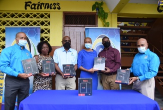 Education, Youth and Information Minister, Hon. Fayval Williams (fourth left) holds one of the 146 tablets distributed to the Holy Family Infant and Primary School during a ceremony held on October 2 at the school, located at Laws Street, downtown Kingston. The initiative falls under the government’s Tablets in Schools programme. Also taking part (from left) are Chief Operating Officer, e-Learning Jamaica Company Limited, Andrew Lee; Guidance Counsellor, Holy Family Infant and Primary School, Marcia Richards; Chief Executive Officer (CEO), e-Learning Jamaica Company Limited, Keith Smith; Principal of Holy Family Infant and Primary School, Christopher Wright; and Chair of the Board of Directors, e-Learning Jamaica Company Limited, Christopher Reckord.