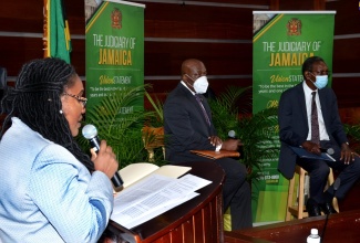 Acting Director of the Court Administration Division (CAD), Tricia Cameron Anglin (left), addresses persons at the Conversation with the Judiciary, held at the Supreme Court on October 29.  Seated (from second left) are Chief Justice, Brian Sykes; and President of the Court of Appeal, Hon. Justice Dennis Morrison.
