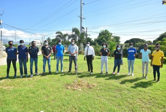 Minister of Housing, Urban Renewal, Environment and Climate Change, the Hon. Pearnel Charles Jr. (sixth right) is flanked by young people at the Youth Month tree-planting ceremony on Wednesday (November 25) at Boulevard Baptist Church in Kingston. ​locked by young people from the Boulevard Baptist Church.