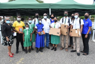 Member of Parliament for South West St. Catherine, Hon. Everald Warmington (centre), with some of the over 200 students who were presented with tablets and laptops, donated by the MP and three business entities in the area, on December 3. Sharing the moment are:  Chairman of the Old Harbour High School, Icylin Golding (left), and representatives of Surdeen Equipment and Trucking, one of the companies which donated some of the devices.