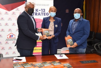 Education, Youth and Information Minister, Hon. Fayval Williams (centre), is presented with a tablet by Director, Administration and Special Projects, Kemtek Development and Construction Limited (KDC), Karl Tulloch (left), during the handover of 100 tablets donated by the corporate entity to five schools, in support of the Ministry’s ‘One Laptop or Tablet per Child Initiative’. Also pictured is Director of Technical Services, KDC, Handel Tulloch. The ceremony was held at the Ministry, in Kingston, on Wednesday (December 9). The beneficiary schools are Steer Town Primary and Junior High, Annotto Bay Primary, York Town Primary, Seaward Primary and Junior High and Seaforth Primary.

