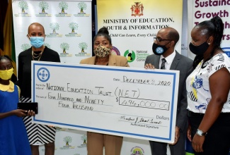 Minister of Education, Youth and Information, Hon. Fayval Williams (second left), holds a cheque for $494,000 presented to the National Education Trust (NET) by the Jamaica Social Stock Exchange (JSSE), under the ‘One Laptop or One Tablet Per Child’ Initiative. The ceremony was held at the Ministry, National Heroes Circle  in Kingston, on Thursday (December 3). With the Minister (from left) are grade-six student, St. Michael’s Primary, Latoya Lancaster; Manager, JSSE, Nora Blake; Group Business Development Manager, JSSE, André Gooden; and grade-six teacher, St. Michael’s Primary, Marissa Francis.  

