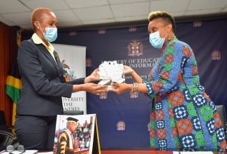 Minister of Education, Youth and Information, Hon. Fayval Williams (left) receives copies of the book 'Voices of the Pelican' from Curator of The University of the West Indies (UWI), Mona Museum, Dr. Shani Roper, at the Ministry's National Heroes Circle location in Kingston on Tuesday (January 19). The books are a compilation of graduation speeches delivered by Sir George Alleyne between 2003 and 2016. They are to be distributed to sixth-form students. 