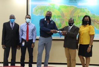 (Centre): Charles Johnson, Commissioned Land Surveyor, receives his survey plan, which is the first to be examined within the new Digital Submission of Survey Plans platform from Dr. Glendon G. Newsome, Senior Director, Surveys and Mapping on December 2, 2020. Also in photo (L-R) Edwards Chambers, Manager, Plan Examination and Certification; Milton Saunders, Manager, Mapping Services; and Cynthia Edwards, Manager, Cadastral Mapping.