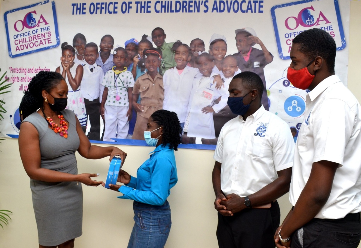 Children’s Advocate, Diahann Gordon Harrison (left), receives two tablets from Assistant National Secretary, Universities and Colleges Apostolic Ministry, Joan Weir, to support chuldren affected by domestic violence, during a ceremony at the Office of the Children’s Advocate (OCA) in Kingston on Wednesday (January 13). Benjamin Fraser (second right) and Rasheem Martin from the Universities and Colleges Apostolic Ministry look on. The organisation also donated $15,000 for the vulnerable children.

