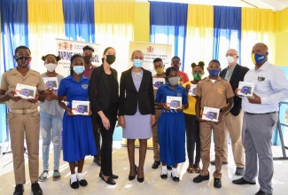 Minister of Education, Youth and Information, Hon. Fayval Williams (sixth left), participates in a ceremony for the handover of 10 tablets by the Spanish Court Hotel, to assist needy students of Papine High School, held at the institution in St. Andrew on Tuesday (January 26). She is flanked by representative of the Spanish Court Hotel, Shanique Leslie (fifth left); Principal of Papine High, Leighton Christie (right); school Board Chairman, David Mais (second right) and students of the school.

