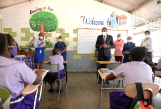 Minister of State in the Ministry of Education, Youth and Information, Hon. Robert Morgan (fourth right), addresses students at the Crescent Primary School in St. Catherine, today (January 5). At third right is Chairman of the school, Councillor Norman Scott.

 