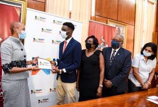 Minister of Education, Youth and Information, Hon. Fayval Williams (left), presents scholarship recipient, Mark Brown (second left) with his award.  Mr. Brown is one of two recipients of scholarships awarded by Massy United Insurance to students pursuing studies in actuarial science at the University of the West Indies (UWI). Sharing in the moment (from third left) are Branch Manager, Jamaica and Cayman Islands, Massy United Insurance, Winsome Gibbs; Pro-Vice Chancellor and Principal, University of the West Indies (UWI), Mona, Prof. Dale Webber; and Head, Maths Department, Faculty of Science and Technology, UWI Mona, Dr. Nagarani Ponakala. The presentation took place during a scholarship handover ceremony, held at the UWI Mona campus on Tuesday (February 9).  The students were awarded scholarships with a combined value of US$10,000 ($1.4 million).

