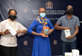 Minister of Education, Youth and Information, Hon. Fayval Williams (centre) displays a tablet, which was among $500,000 worth of items donated by the Building Alternative Bridges for Success (BABS) Foundation, in support of the Ministry's coronavirus (COVID-19) response. The items were handed over at the Ministry's  National Heroes Circle offices in Kingston on Tuesday (February 23).  Acting Chief Education Officer, Dr. Kasan Troupe (left), holds an automatic sanitiser dispenser, while Director of the BABS Foundation, Adrian Reynolds, displays a non-contact thermometer.

