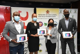 Education, Youth and Information Minister, Hon. Fayval Williams (second left), and Restaurants of Jamaica (ROJ) Limited Marketing Director, Tina Myers Matalon (third left), display tablets during a handover ceremony at the Ministry of Education, Youth and Information, National Heroes Circle, in Kingston, on February 3.  Also displaying tablets are international recording artiste and Kentucky Fried Chicken (KFC) ‘Add Hope’ Ambassador, Kevin Downswell (left), and ROJ Brand Manager, Andrei Roper. The devices were donated to the Ministry by ROJ under the ‘One Laptop or Tablet Per Child’ initiative.  

