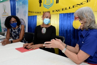 Minister of  Education, Youth and Information, Hon. Fayval Williams (centre), listens to a point from Chairman, National Commercial Bank (NCB) Foundation, Thalia Lyn (right), during a ceremony for the hand over of tablets by the National Commercial Bank (NCB) Foundation, to students of the Constant Spring Primary and Junior High School, at the institution's Cassava Piece Road location in St. Andrew on February 3. Chief Executive Officer of the NCB Foundation, Nadeen Matthews Blair, shares in the discussion.

