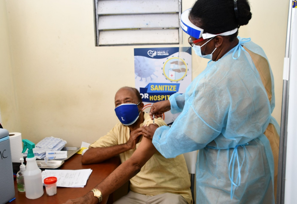 Former Cabinet Minisister, Dr. Karl Blythe (left), is given the COVID-19 vaccine by Public Health Nurse at the Westmoreland Health Department, Jacqueline Smith, on Thursday (March 11).