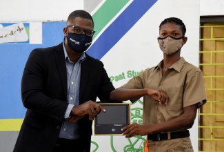 President of the Vauxhall High School Alumni Association, Jamaica Chapter, Timar Jackson (left), presents grade-nine student, Ishmael Small, with a tablet. The occasion was a ceremony for the handover of 61 tablets donated by the alumni association's New York chapter, at the institution’s Windward Road address in Kingston, recently.