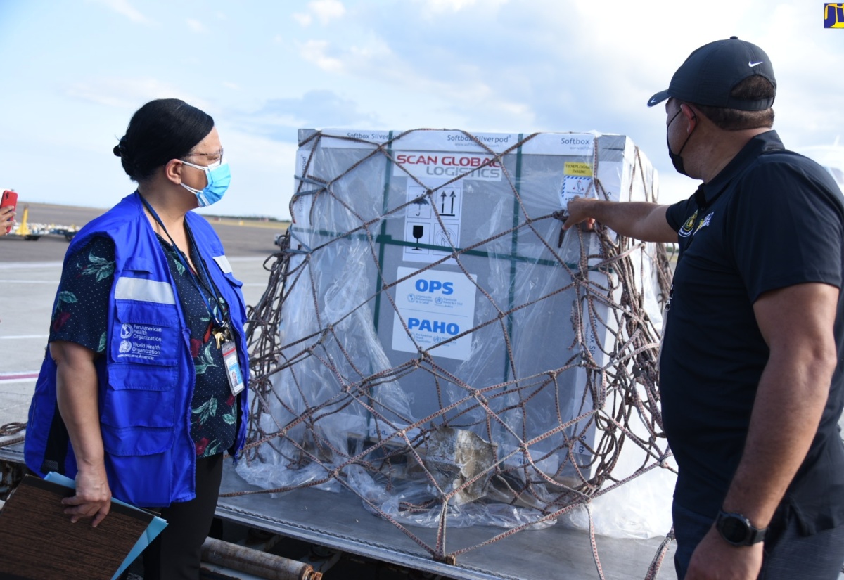 Minister of Health and Wellness, Dr. the Hon. Christopher Tufton (right), examines  a shipment of AstraZeneca vaccine from the COVAX Facility, which arrived at the Norman Manley International Airport on Monday (April 26).  Sharing the moment (at left) is  PAHO/WHO Country Representative for Jamaica, Bermuda and the Cayman Islands, Bernadette Theodore Gandi. 


