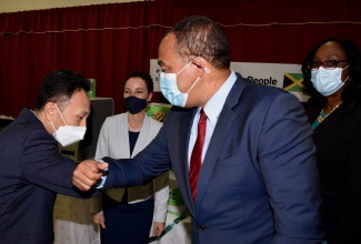 Minister of Health and Wellness, Dr. the Hon. Christopher Tufton (right), greets Chargé d'Affaires of the Embassy of the Republic of Korea to Jamaica, Lim Baejin (left), during a ceremony to hand over COVID-19 testing supplies from the Embassy at the National Public Health Laboratory, 21 Slipe Pen Road, Kingston, on April 20. Also sharing the moment are Minister of Foreign Affairs and Foreign Trade, Senator the Hon. Kamina Johnson Smith (second left) and Director of the National Laboratory Services, Dr. Michelle Hamilton.

