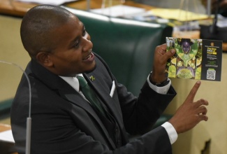 Minister of Agriculture and Fisheries, Hon. Floyd Green, holds a poster with the logo for the new FACE of food initiative during his presentation in  the Sectoral Debate in the House of Representatives, on Wednesday (May 12).