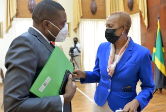 Minister of Education, Youth and Information, Hon. Fayval Williams (right), discusses a matter of importance with State Minister in the Ministry of Education, Youth and Information, Hon. Robert Morgan, shortly before the start of a post-Cabinet press briefing,​ which was hosted virtually from Jamaica House on Wednesday (May 5). 

