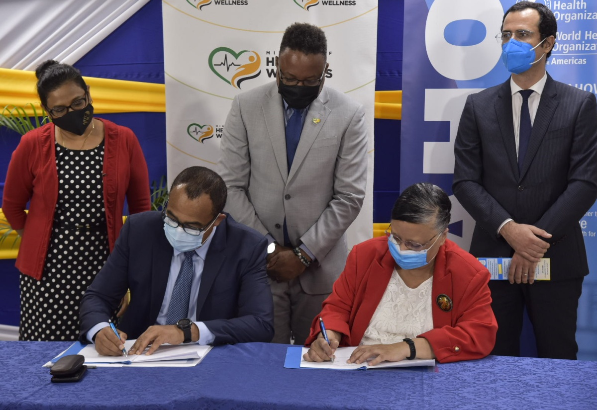 Minister of Health and Wellness, Dr. the Hon. Christopher Tufton (second left), and Country Representative in  Jamaica for the Pan American Health Organization (PAHO)/World Health Organization (WHO), Dr. Bernadette Theodore-Gandi, sign a Technical Assistance agreement that will help to advance Jamaica’s healthcare systems and services, on June 22. Observing (from left) are Chief Medical Officer in the Ministry of Health and Wellness, Dr. Jacquiline Bisasor-Mckenzie; Permanent Secretary in the Ministry of Health and Wellness, Dunstan Bryan,  and Advisor for Health Systems and Services at PAHO, Casimiro Dias.  