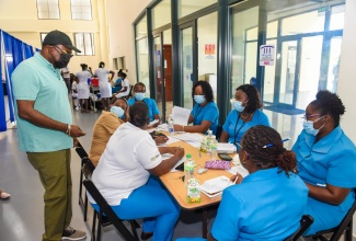 Tourism Minister, Hon. Edmund Bartlett (left) expresses sincere appreciation to St. James Public Health Department staff and other healthcare workers for their commitment in going the extra mile to vaccinate the public against the coronavirus (COVID-19). Minister Bartlett lauded the workers as he visited the vaccination blitz site at the Montego Bay Convention Centre on Saturday, June 19, 2021. He underscored that healthcare workers have a crucial role to play in enabling the quick recovery, not just of the tourism sector, but of the Jamaican economy overall.   